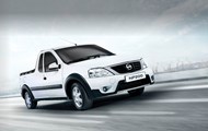 White Nissan NP200 driving on tar road